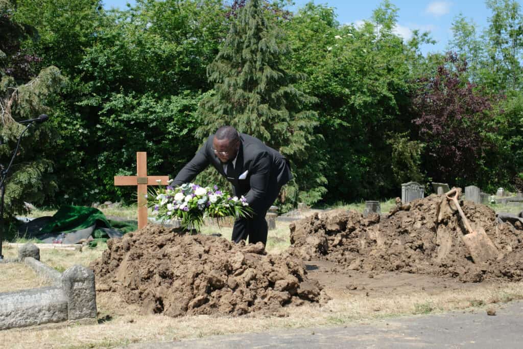 A man placing flowers on a grave